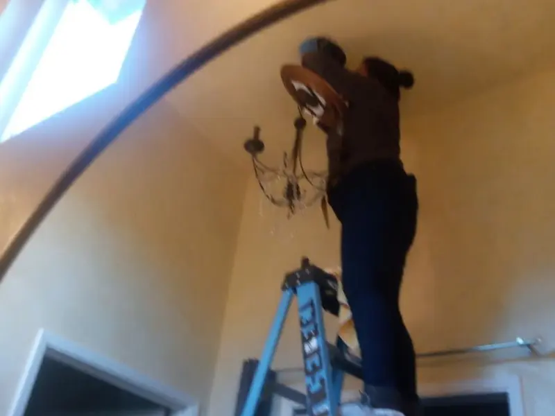 Electrician installing a chandelier in a Cave Spring residence